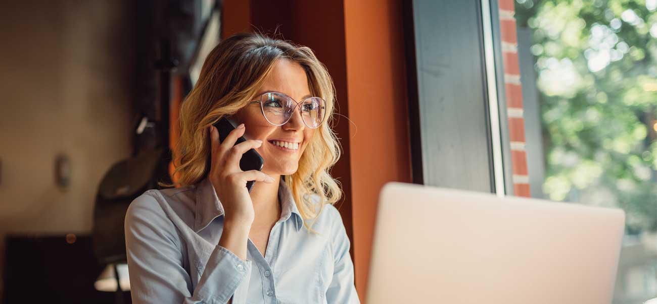 Woman on phone with laptop